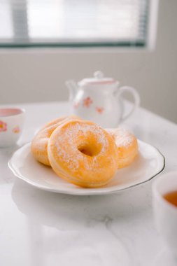 Klasik çörek ve kahve Kupası beyaz masada.