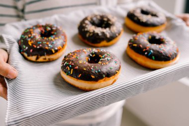 Beyaz zemin üzerine çikolatalı çörek kutusuyla holding erkek eller