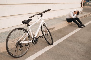mutsuz Asya adam sokakta Bisiklet yakınındaki telefon kullanma. 