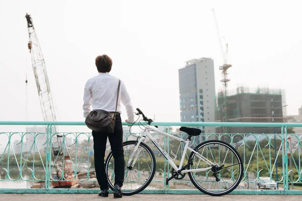 Человек Велосипедом Стоит Мосту Смотрит Город — стоковое фото