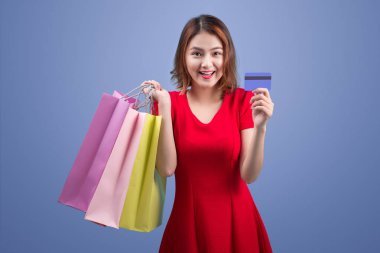 Menekşe karşı holding alışveriş torbaları ve kredi kartı Santa Asyalı kadın