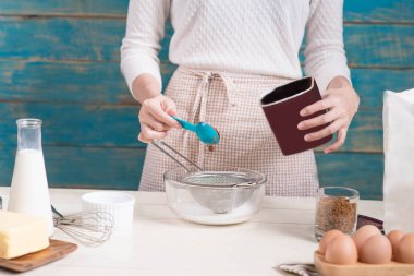 Ev kadını önlük yapımı giyiyor. Yemek çikolata kek yapma adımları.