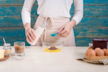 Ev kadını önlük yapımı giyiyor. Yemek çikolata kek yapma adımları.