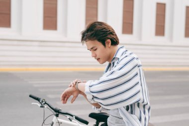 Bakarak genç yakışıklı adamla sokakta, Bisiklet.