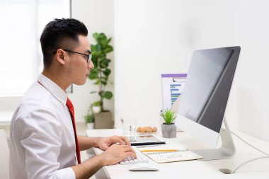 Modern ofis onun masasında çalışan gülümseyen tasarımcı