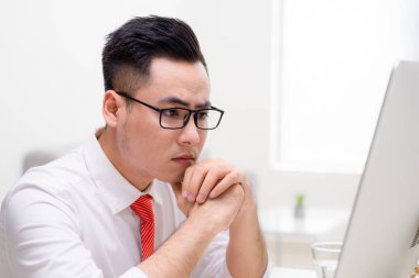 Bilgisayar ile çalışma ve nasıl zor bir görev çözmek için düşünme ofisinde genç şık işçi