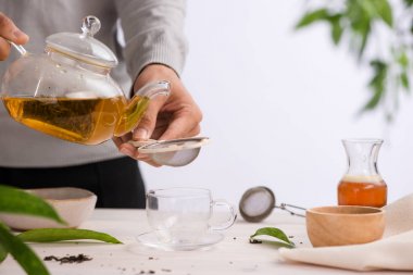 Ahşap masa üzerinde çay çaydanlık bardaktan dökülür