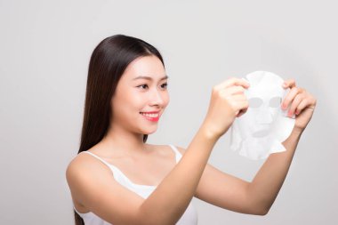 Güzel Asyalı kadın yüzüne kağıt örtü takıyor. Beyaz arka plan..