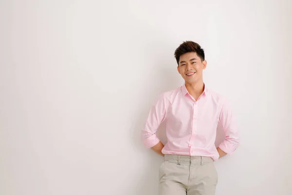 Красивый Азиатский Мужчина Стоит Улыбается Позируя Розовой Рубашке Сером Фоне — стоковое фото