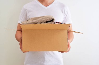 Kıyafet bağış kutusu tutan bir adam. Bağış konsepti.