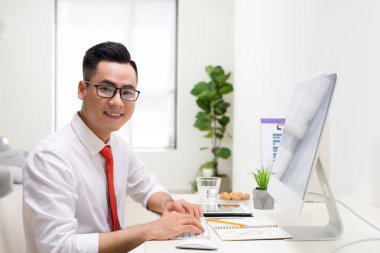 Modern ofis onun masasında çalışan gülümseyen tasarımcı