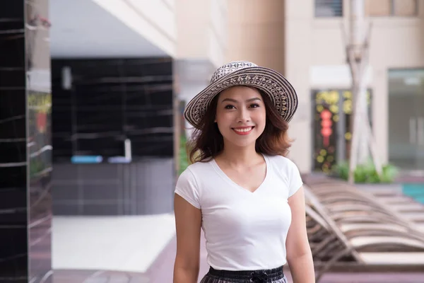 Isolated portrait of smiling  Asian woman wearing big summer hat