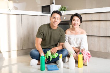 Genç mutlu Asyalı çift evde temizlik yaparken eğleniyor. Temizlik kavramı.