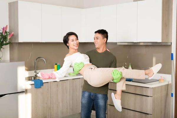 Młody Mąż Obejmujący Żonę Podczas Sprzątania Kuchni — Zdjęcie stockowe