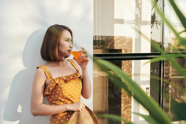 幸せな夏の女性楽しみオレンジジュース壁の後ろ — ストック写真