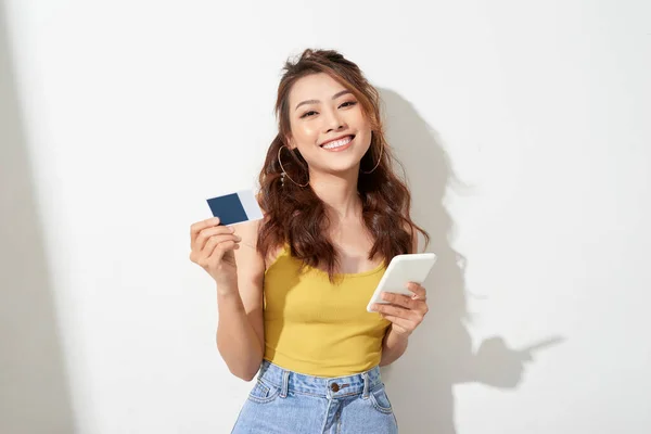 Asian young woman holding a card and mobile phone