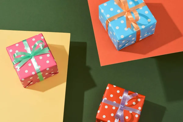 Karácsonyi ajándékdobozok szalagokkal a színes asztalra — Stock Fotó
