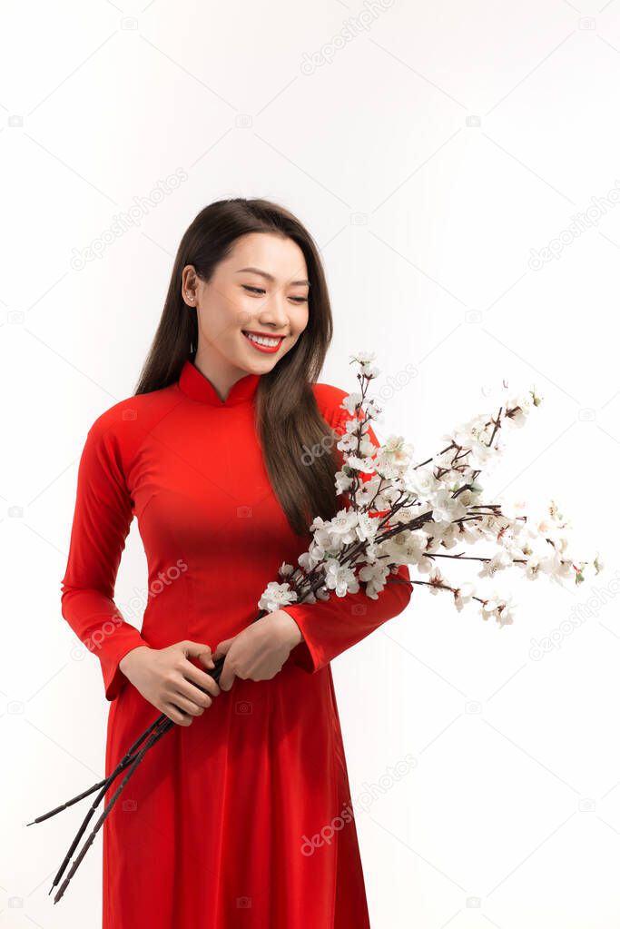 Women wear Vietnam traditional ao dai holding peach blooms in Tet holidays