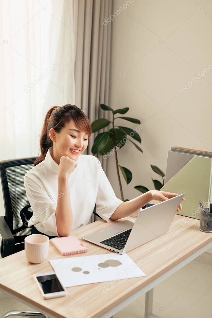 Young Asian beautiful woman works for a computer from a home with a laptop at desk as a freelancer