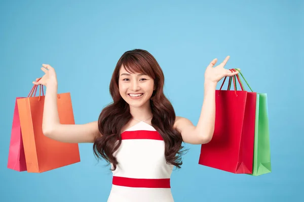 Schöne Junge Asiatische Frau Mit Einkaufstaschen Auf Blauem Hintergrund — Stockfoto