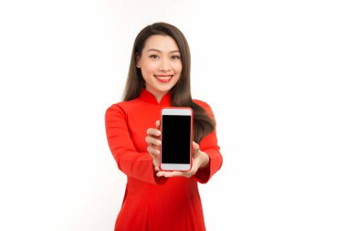 Aao dai 'de duran Asyalı genç bir kadının portresi boş ekranlı cep telefonunu gösteriyor.