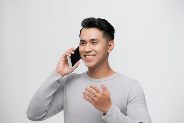 Задумчивый Счастливый Азиат Улыбается Разговаривая Мобильному Телефону Изолированы Белом Фоне — стоковое фото