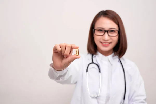 白い背景に水と薬を保持している医師の女性 — ストック写真
