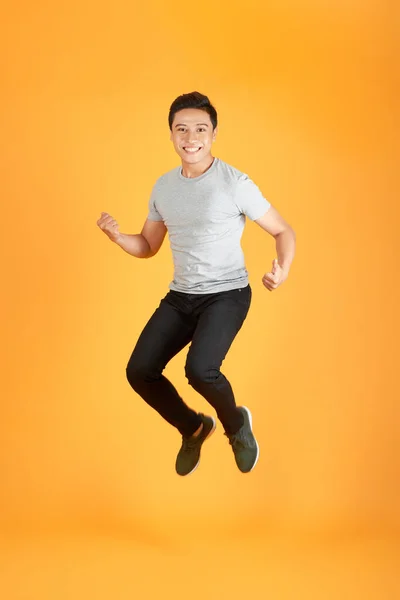 Energický Šťastný Mladý Asijský Muž Ležérní Oblečení Jumping Studio Shot — Stock fotografie