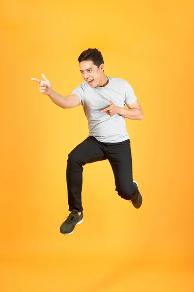 Alegre Joven Asiático Hombre Vestido Camiseta Saltar Sobre Naranja Fondo — Foto de Stock