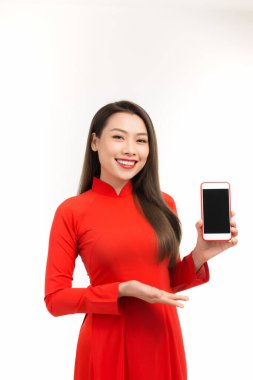 Aao dai 'de duran Asyalı genç bir kadının portresi boş ekranlı cep telefonunu gösteriyor.