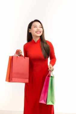 Happy Vietnamese women's dress traditional ao dai at New Year with shopping bag