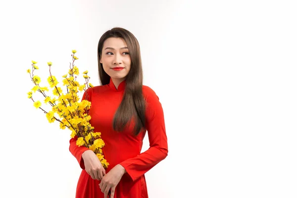 アジアの女性で赤伝統的なベトナムのドレス保持アプリコットの花の花束と笑顔 — ストック写真