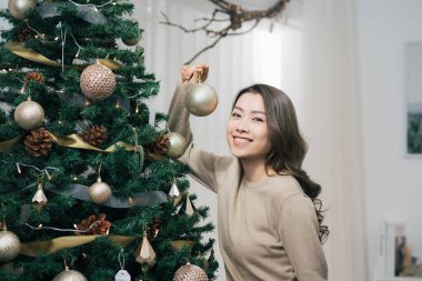 Mutlu genç Asyalı kadın Noel ağacı ev dekorasyon