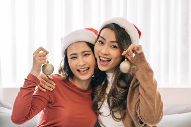 Asyalı aşığın kız arkadaşı Noel partisinde sarılıyor ve Noel hediyesi veriyor.