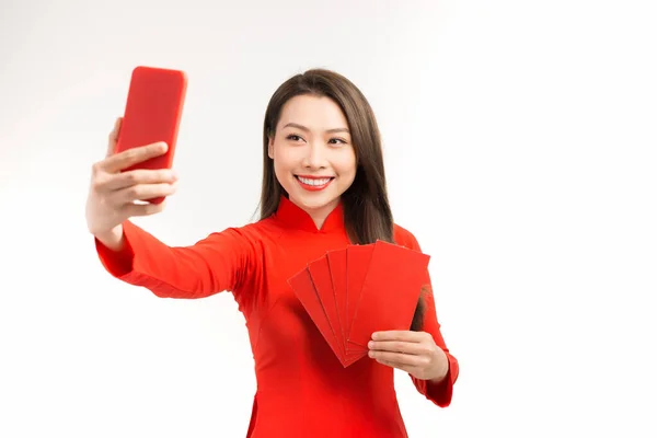 Улыбающаяся Вьетнамская Женщина Делает Селфи Мобильному Телефону Красными Конвертами Белом — стоковое фото