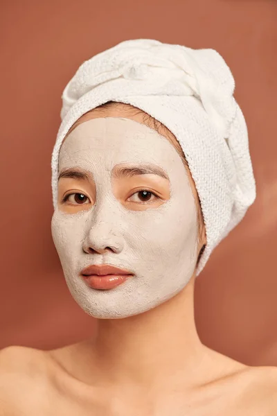 Portret Młodej Azjatki Pomarańczowym Tle Glinianą Maską Twarzy Ręcznikiem Głowie — Zdjęcie stockowe