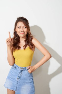 Genç ve çekici Asyalı kadın parmağıyla işaret ediyor.