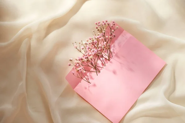 春の花序を持つピンクの封筒 フラットレイアウト トップビュー — ストック写真