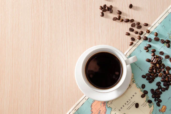 Eine Weiße Tasse Kaffee Mit Kaffeebohnen Und Landkarte Auf Holzgrund — Stockfoto