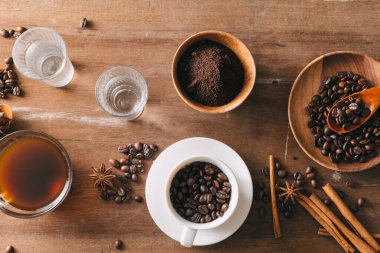 Aksesuarlar ile bir kompozisyon içinde kahve çekirdekleri arka planda bir fincan siyah kahve