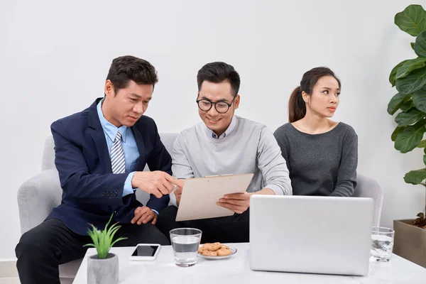 Real estate agent working with couple of customers in the office