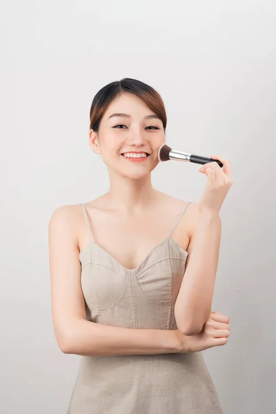 Neşeli Kadın Fırça Kullanarak Yüzünde Makyaj Yapıyor Beyaz Arka Planda — Stok fotoğraf