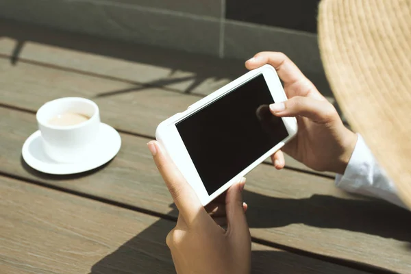 Attrappe Bild der Hände mit schwarzem Handy unter der Sonne bei coff — Stockfoto