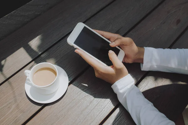 Mensajes de texto de mano de mujer para alguien con pantalla negra en la cafetería —  Fotos de Stock