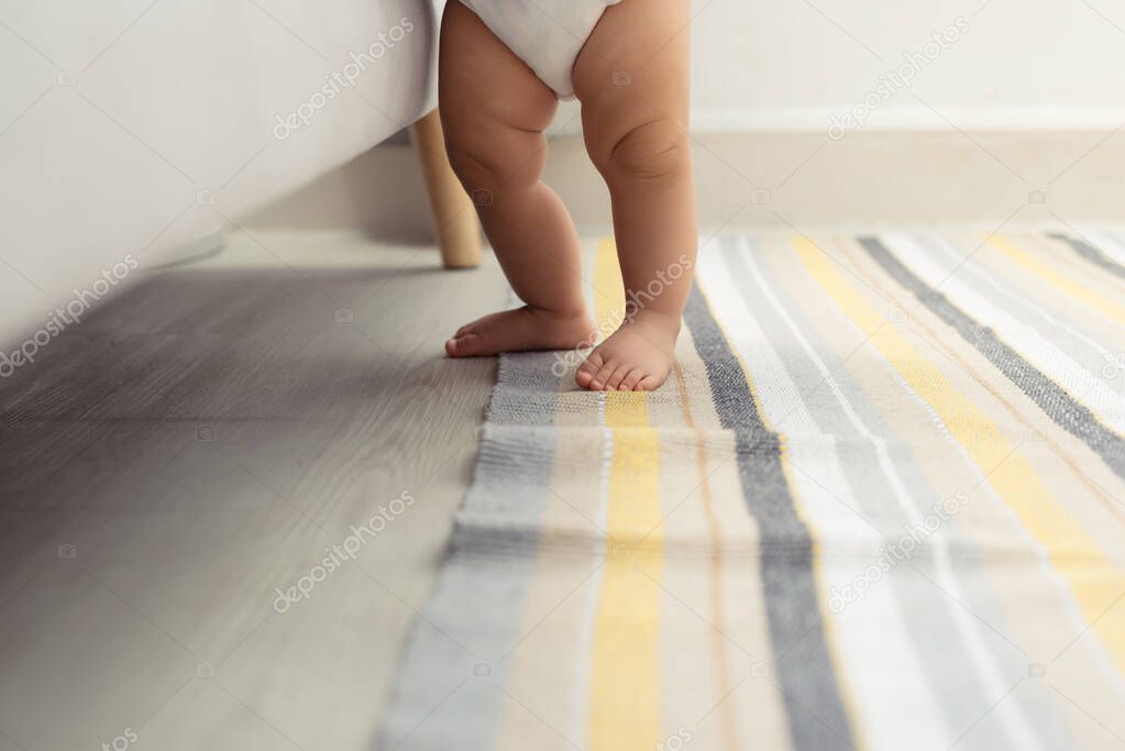 Close up toddler girl legs standing on floor. 