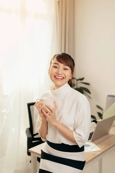 Junge Asiatische Geschäftsfrau Sitzt Auf Dem Schreibtisch Während Sie Kaffeetasse — Stockfoto