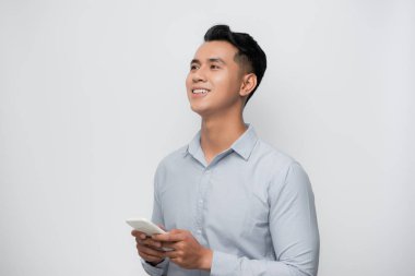Yakışıklı Asyalı adamın gülen yüzü. Akıllı telefon kullan..