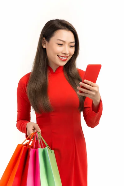 春天快乐的女人喜欢拿着智能手机和色彩斑斓的白色背景购物袋购物 — 图库照片