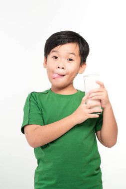 Küçük çocuk beyaz arka planda farklı duyguları olan bir bardak süt içiyor.