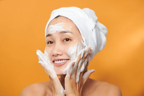 Rindo menina aplicando creme hidratante em seu rosto. Foto de — Fotografia de Stock